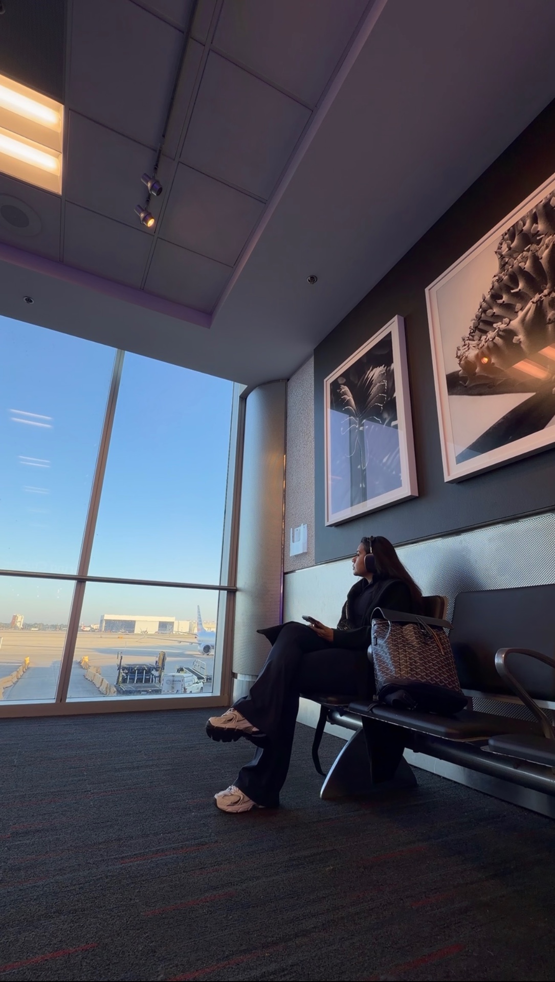 Alicia wearing headphones while waiting at the airport